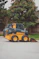a yellow and black skid steer parked in a parking lot