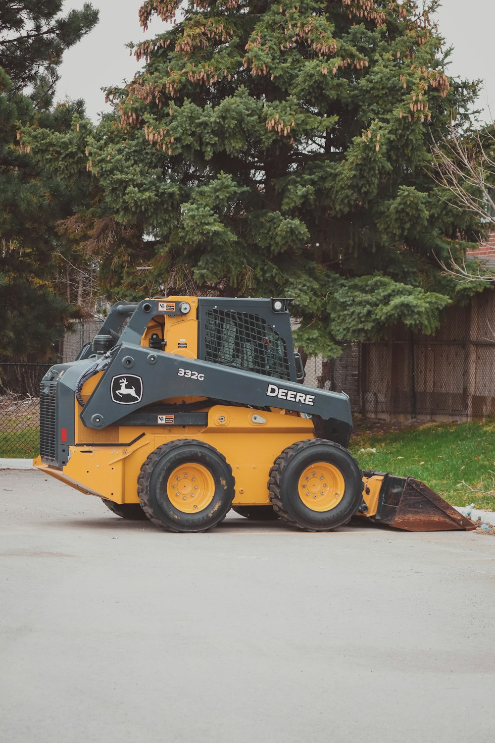 a yellow and black skid steer parked in a parking lot