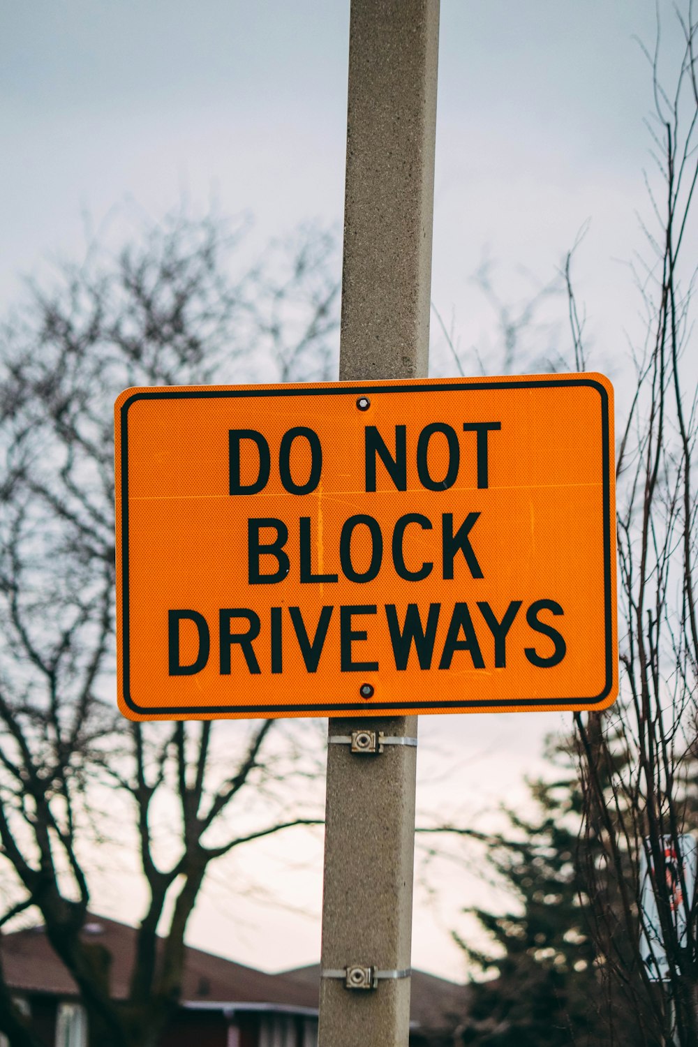 Una señal de no bloquear el camino de entrada en un poste