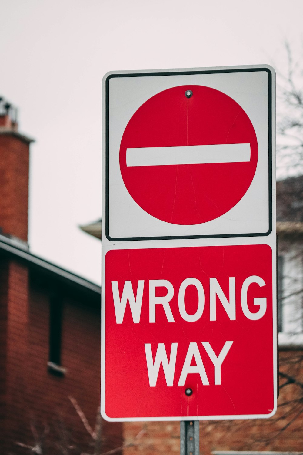 a red and white sign that says wrong way
