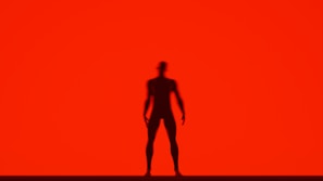 A cinematic still from a brand film featuring a powerful silhouette against a red backdrop
