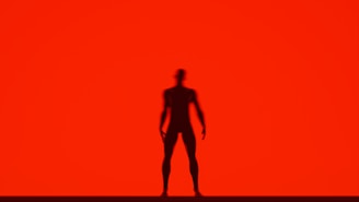 A cinematic still from a brand film featuring a powerful silhouette against a red backdrop
