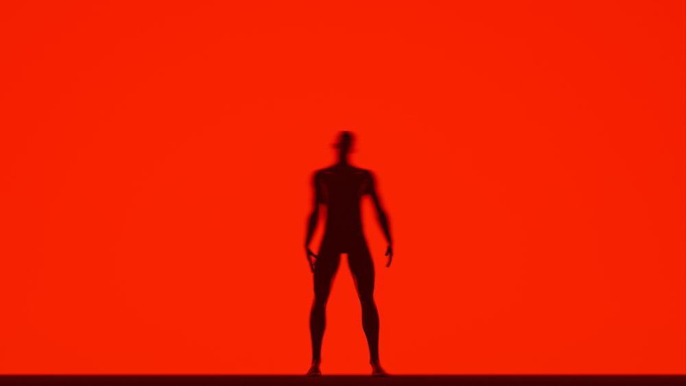 a shadow of a person standing in front of a red background