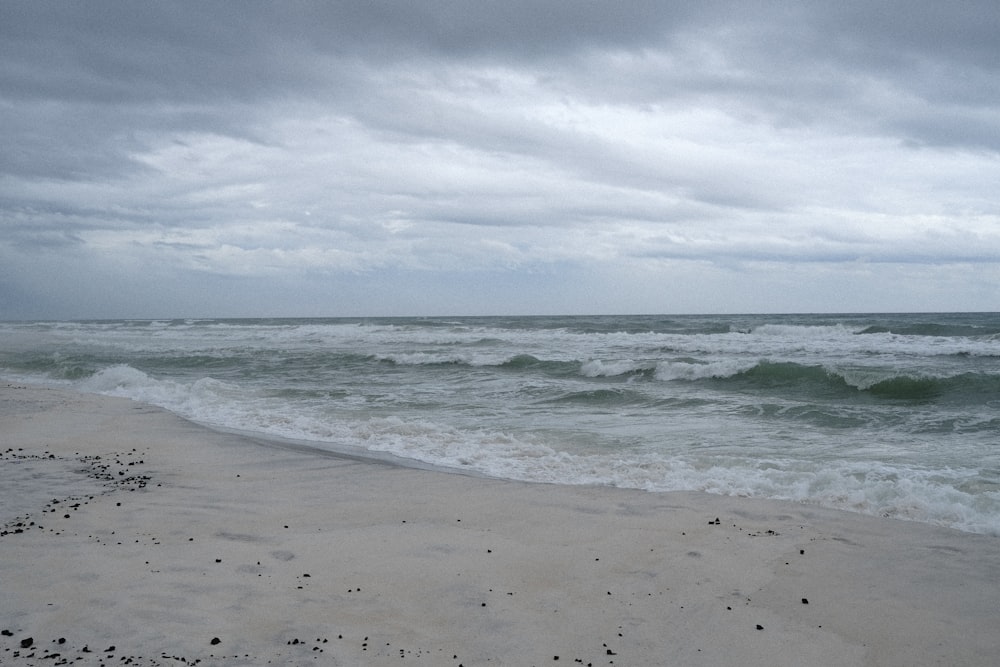 a sandy beach with waves coming in to shore