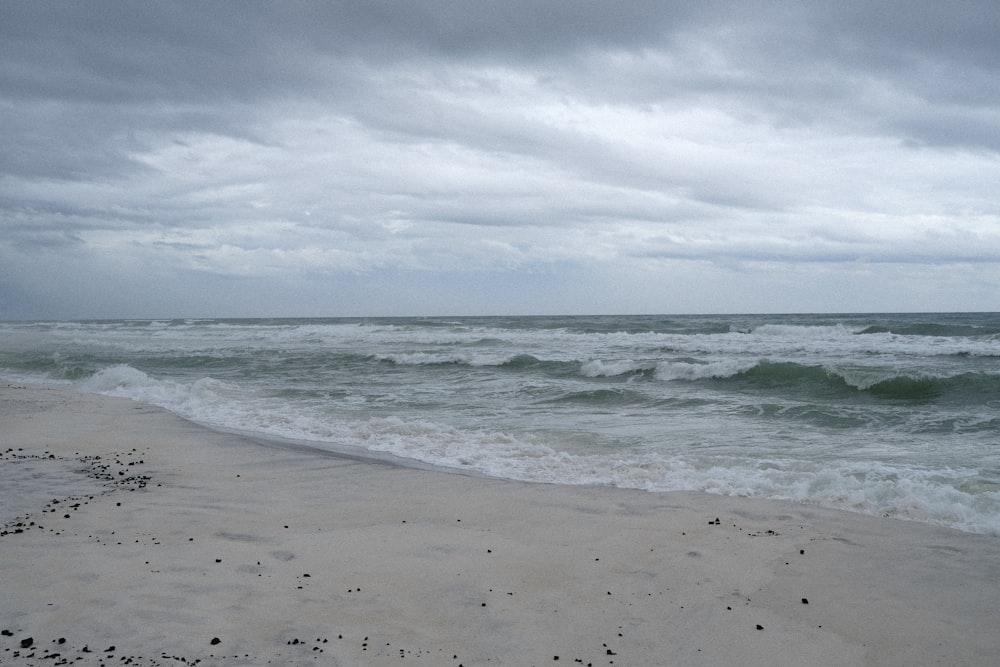 Una playa de arena con olas que llegan a la orilla