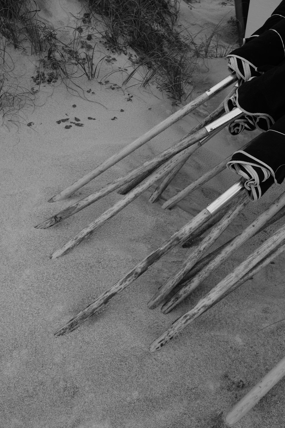 a group of skis sitting on top of a sandy beach