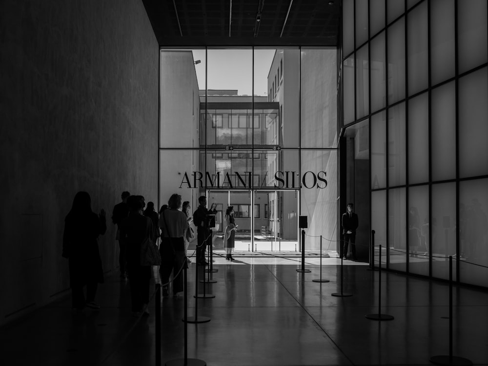 a black and white photo of people standing in front of a building