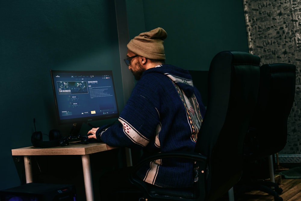 a man sitting in front of a computer monitor
