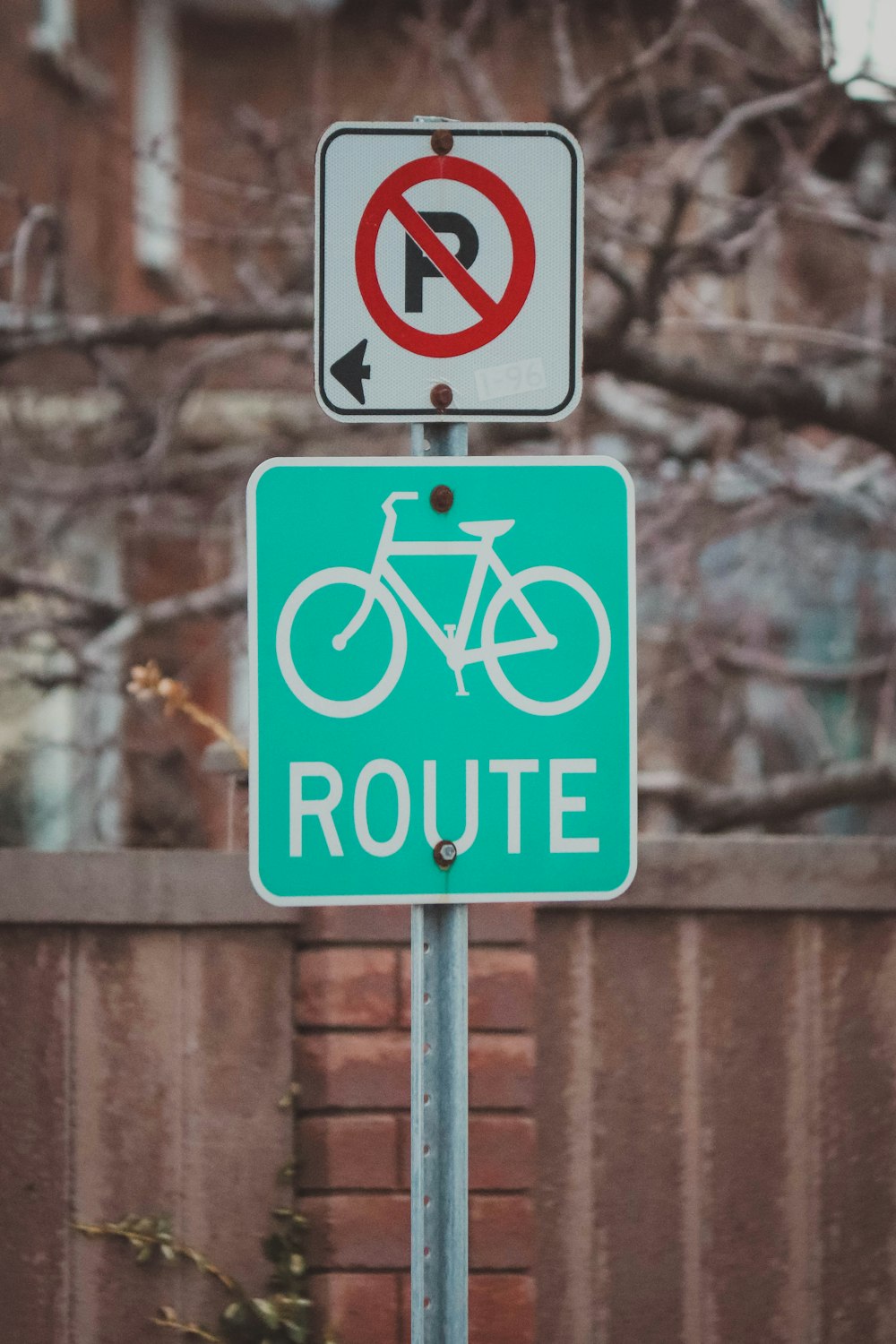 a no parking sign and a bicycle sign on a pole