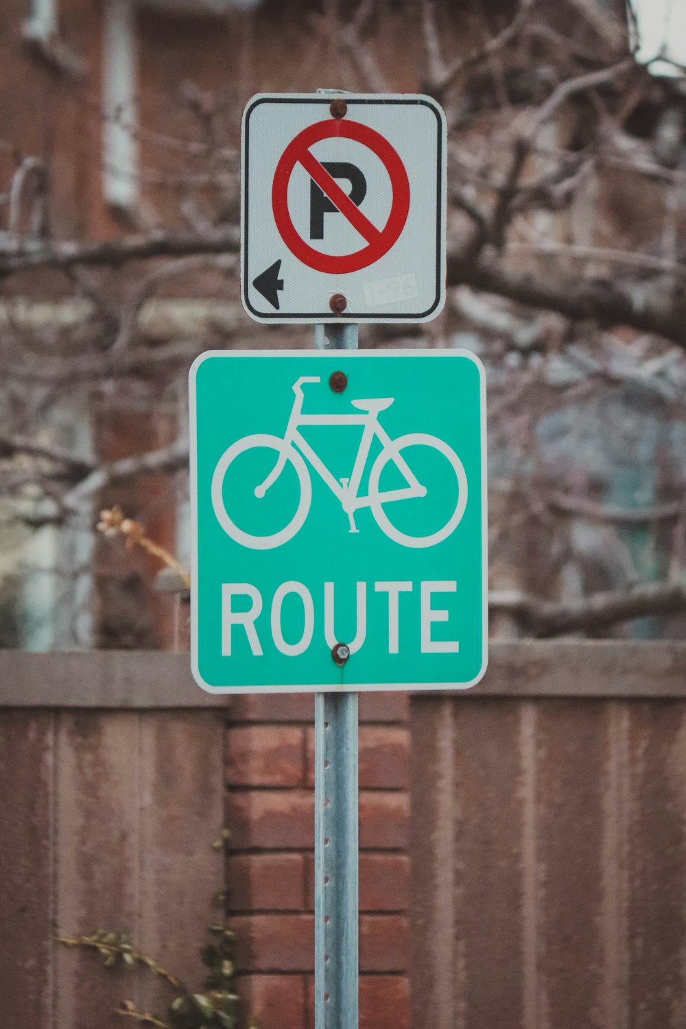 una señal de no estacionamiento y una señal de bicicleta en un poste