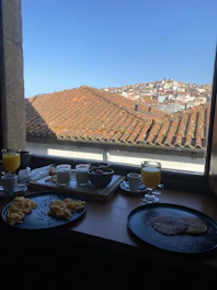Guests enjoying a hearty breakfast on a sunlit terrace overlooking Ujjain's skyline.