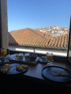 Guests enjoying a hearty breakfast on a sunlit terrace overlooking Ujjain's skyline.
