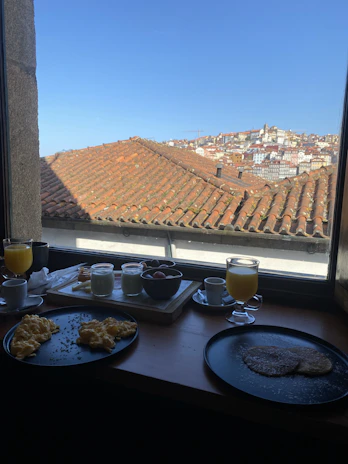 Smiling guest enjoying breakfast on the hotel terrace with city view.