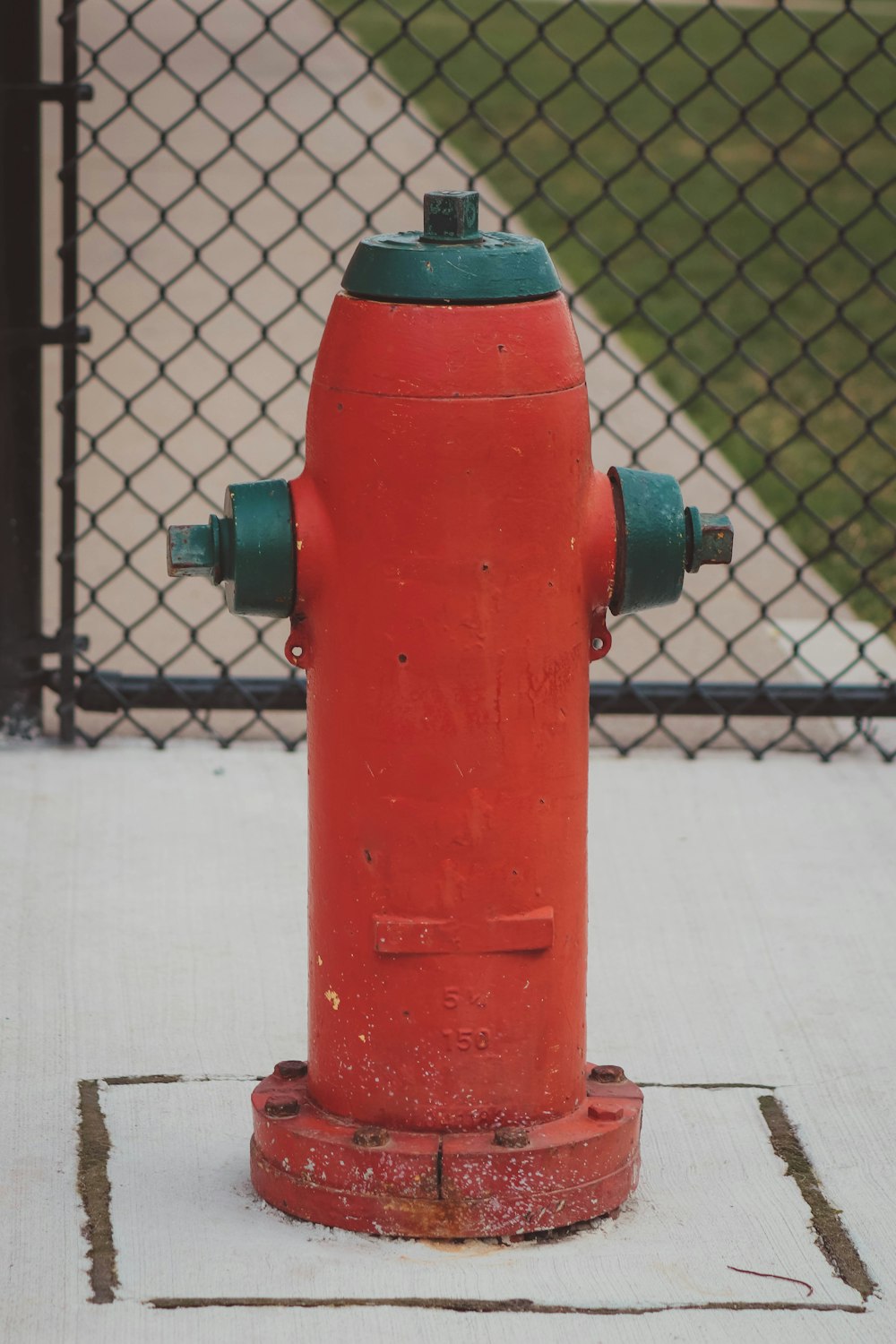 a red and green fire hydrant sitting on a sidewalk