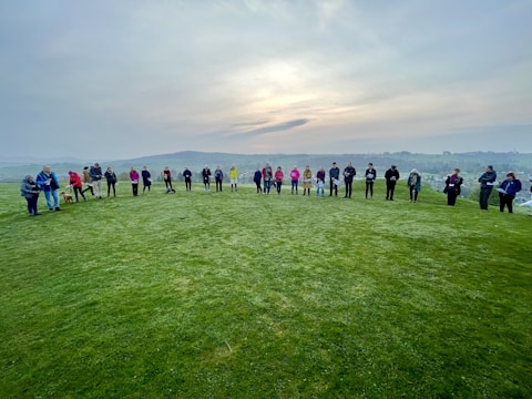 A group prayer circle outside the church on a sunny day.