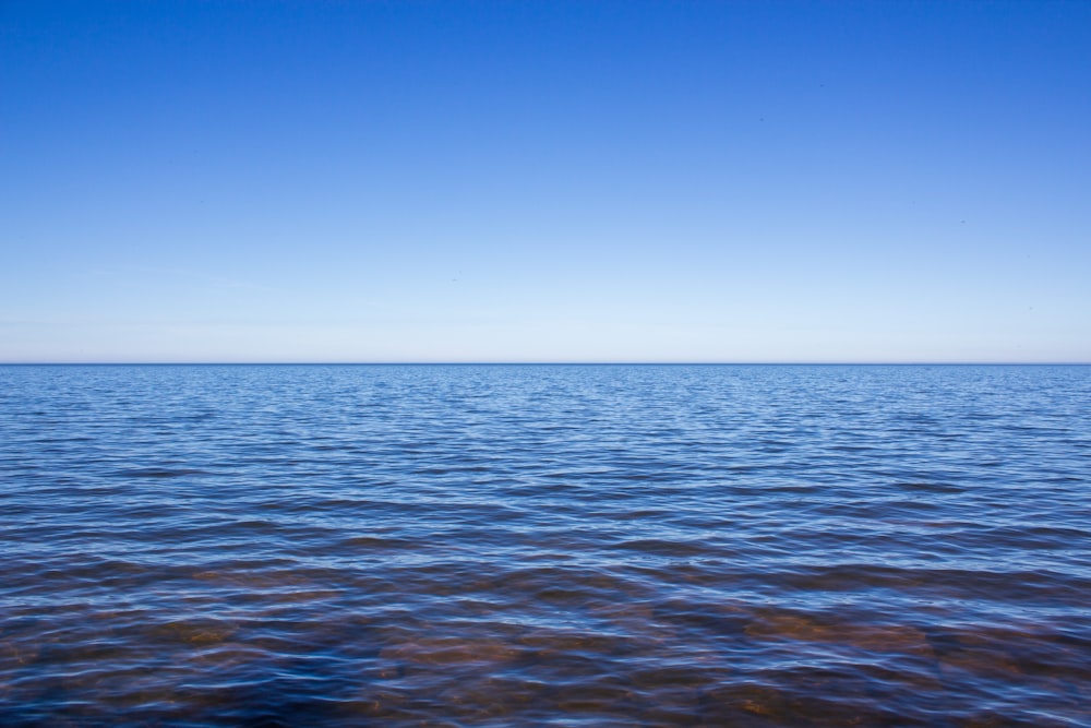 a body of water with a blue sky in the background