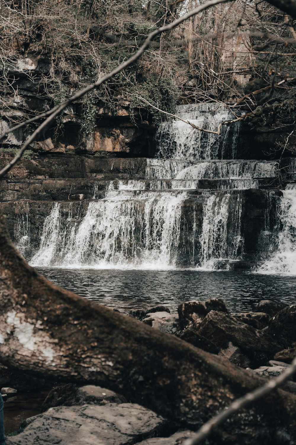 Un homme debout devant une cascade