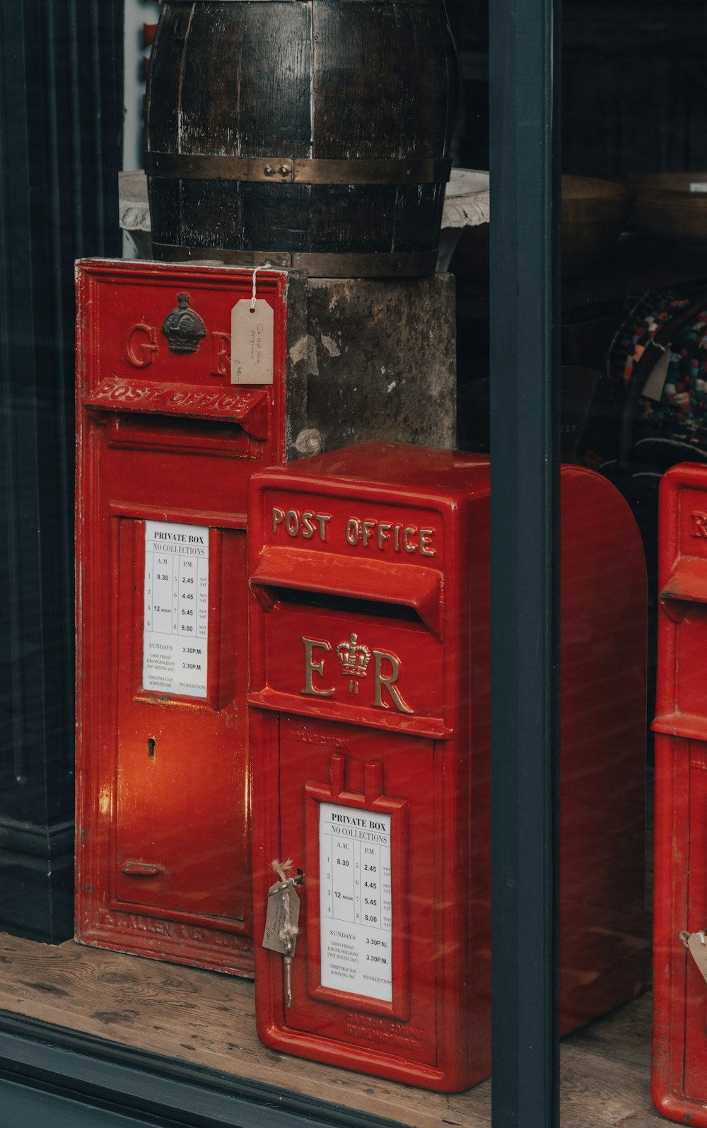 two red mail boxes sitting outside of a building