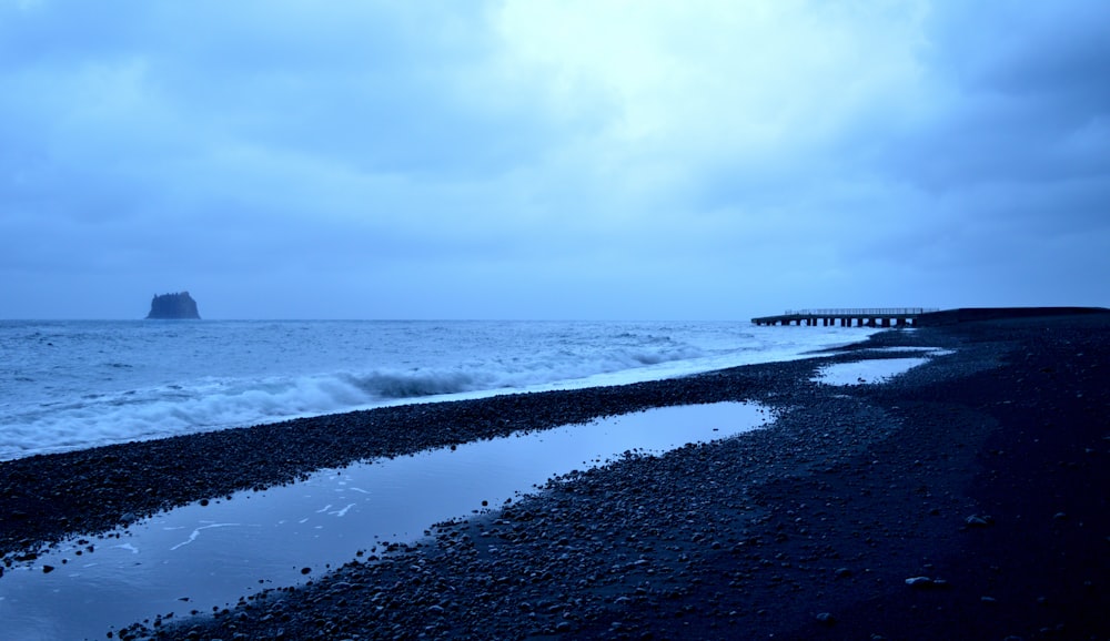 a body of water sitting next to a rocky beach