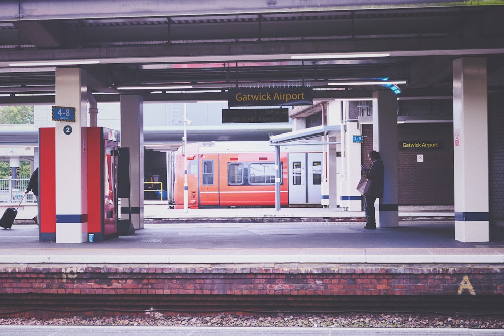 a train at a train station with a man standing next to it