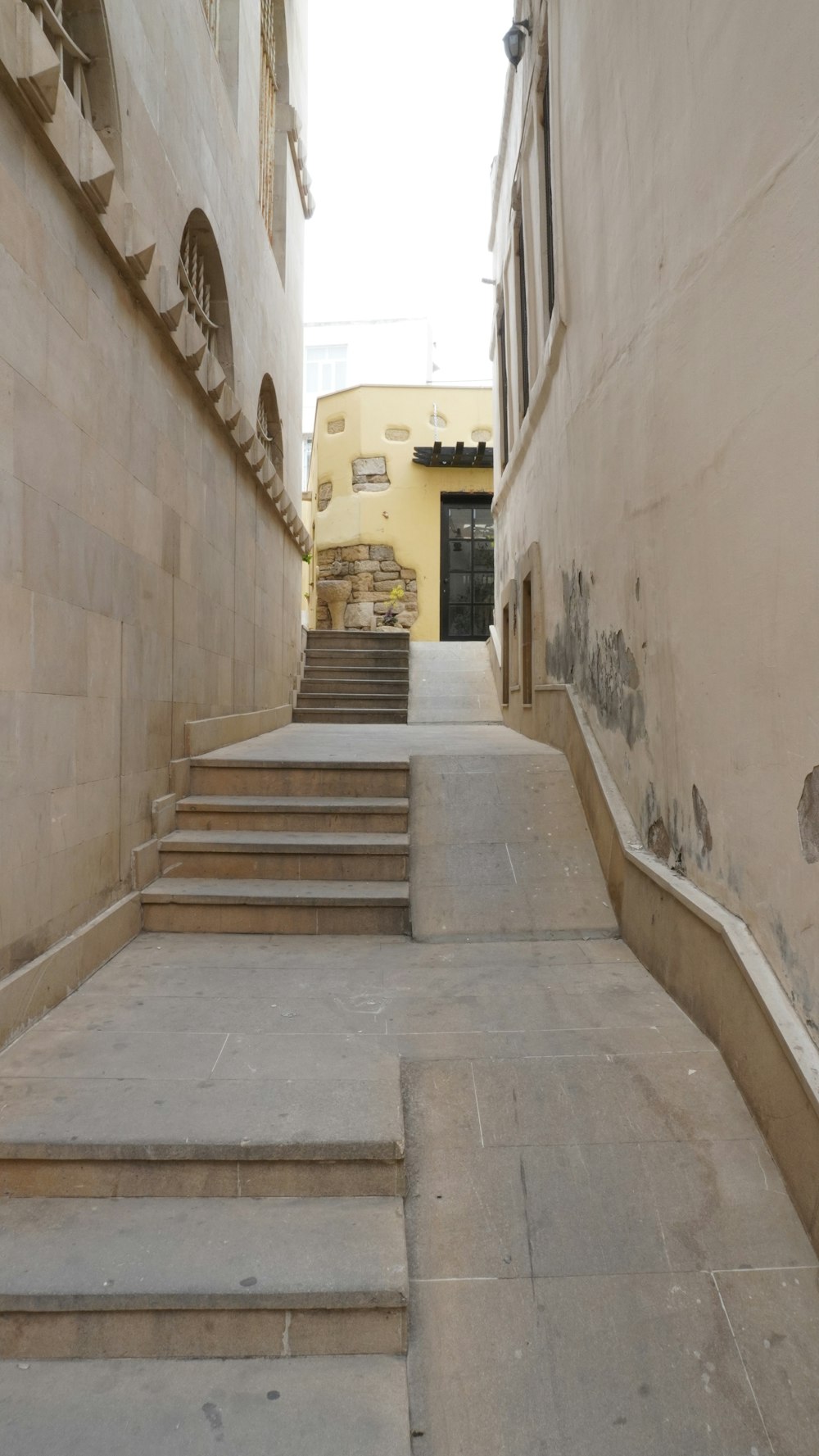 a set of stone steps leading up to a yellow building