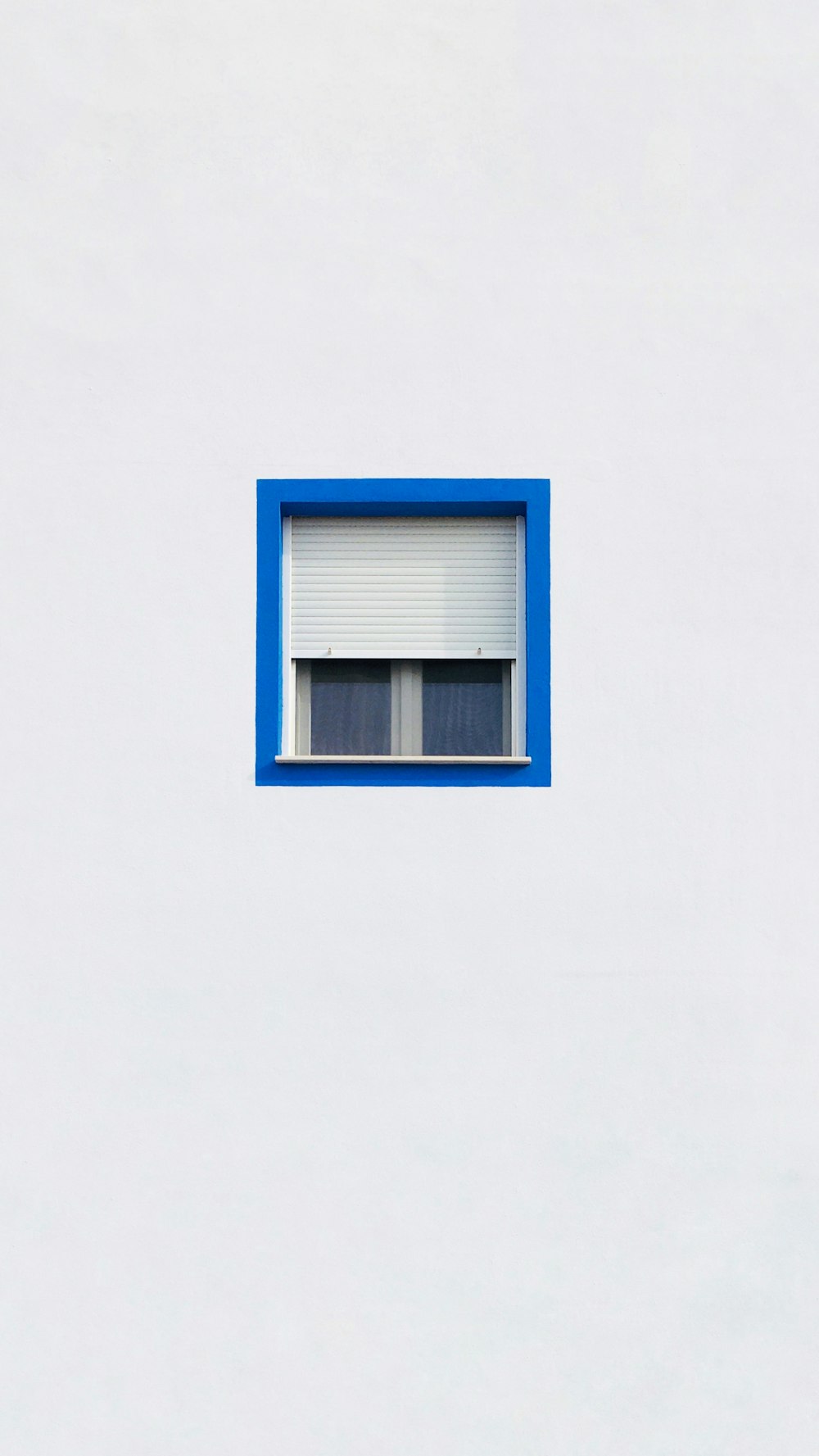 a white building with a blue window in the middle of it