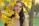a woman standing under a tree with yellow leaves