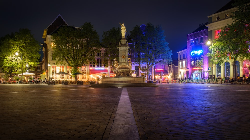 a city street at night with buildings lit up