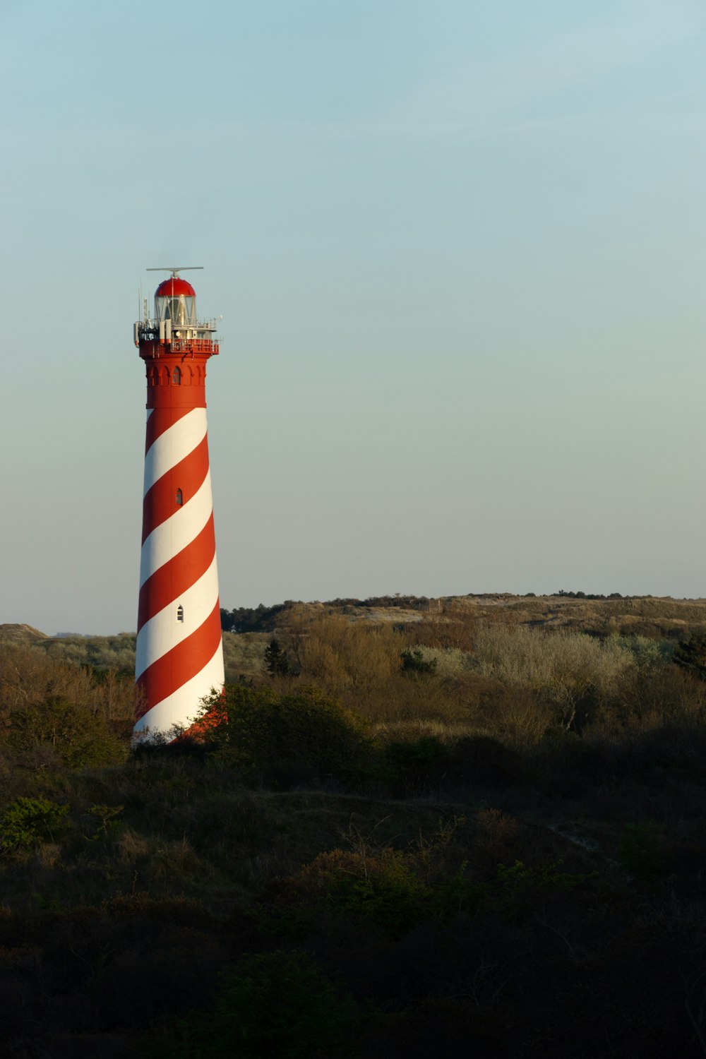 a red and white light house in a field