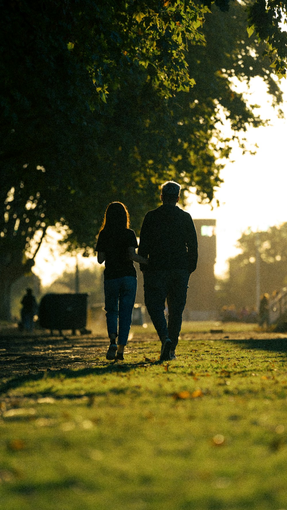 a man and a woman walking down a path