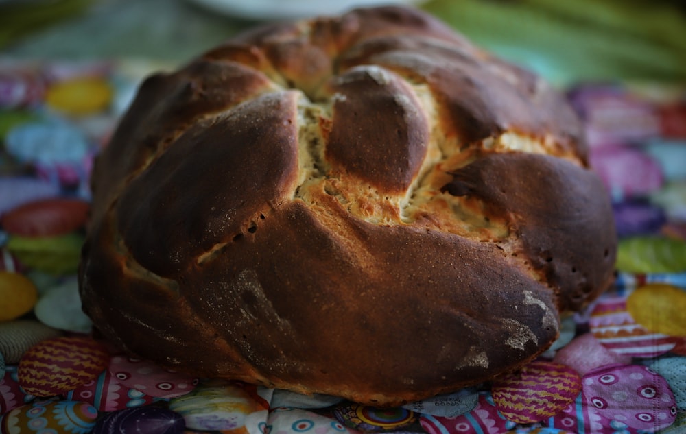 a loaf of bread sitting on top of a colorful table cloth