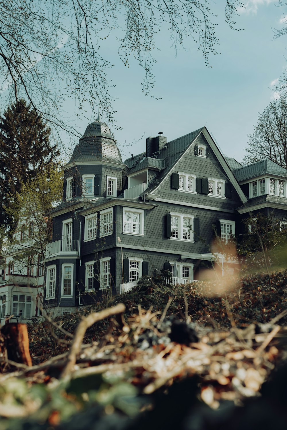 a large gray house sitting on top of a hill