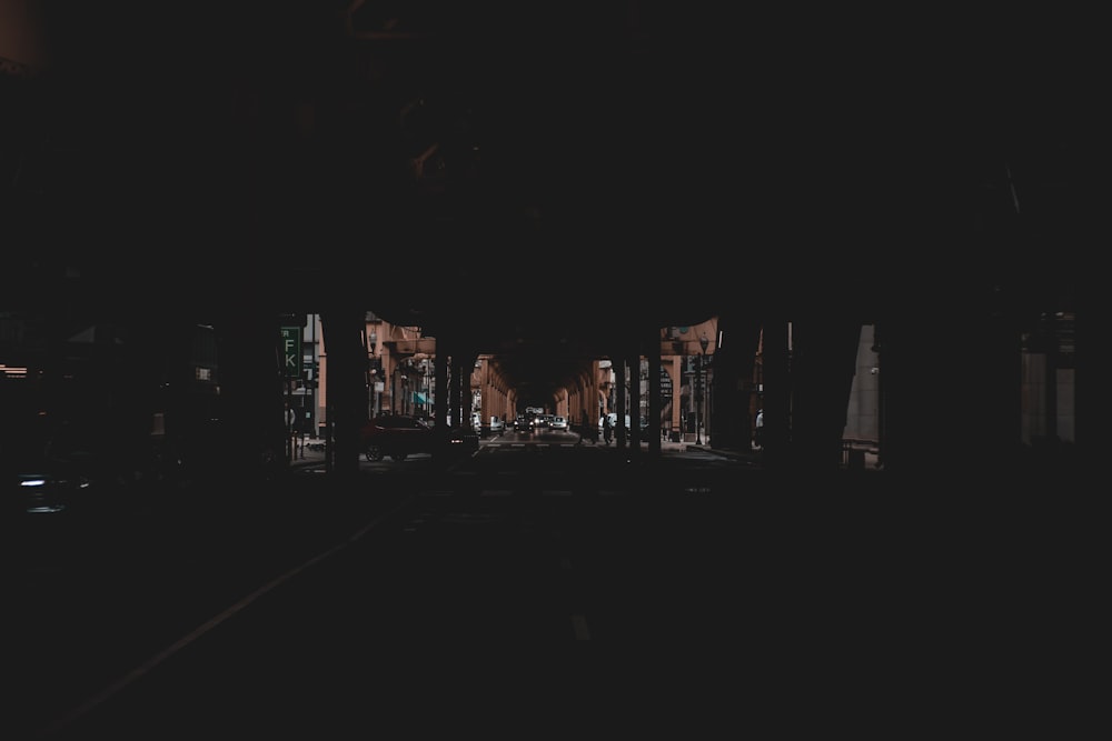 a dark street at night with buildings lit up