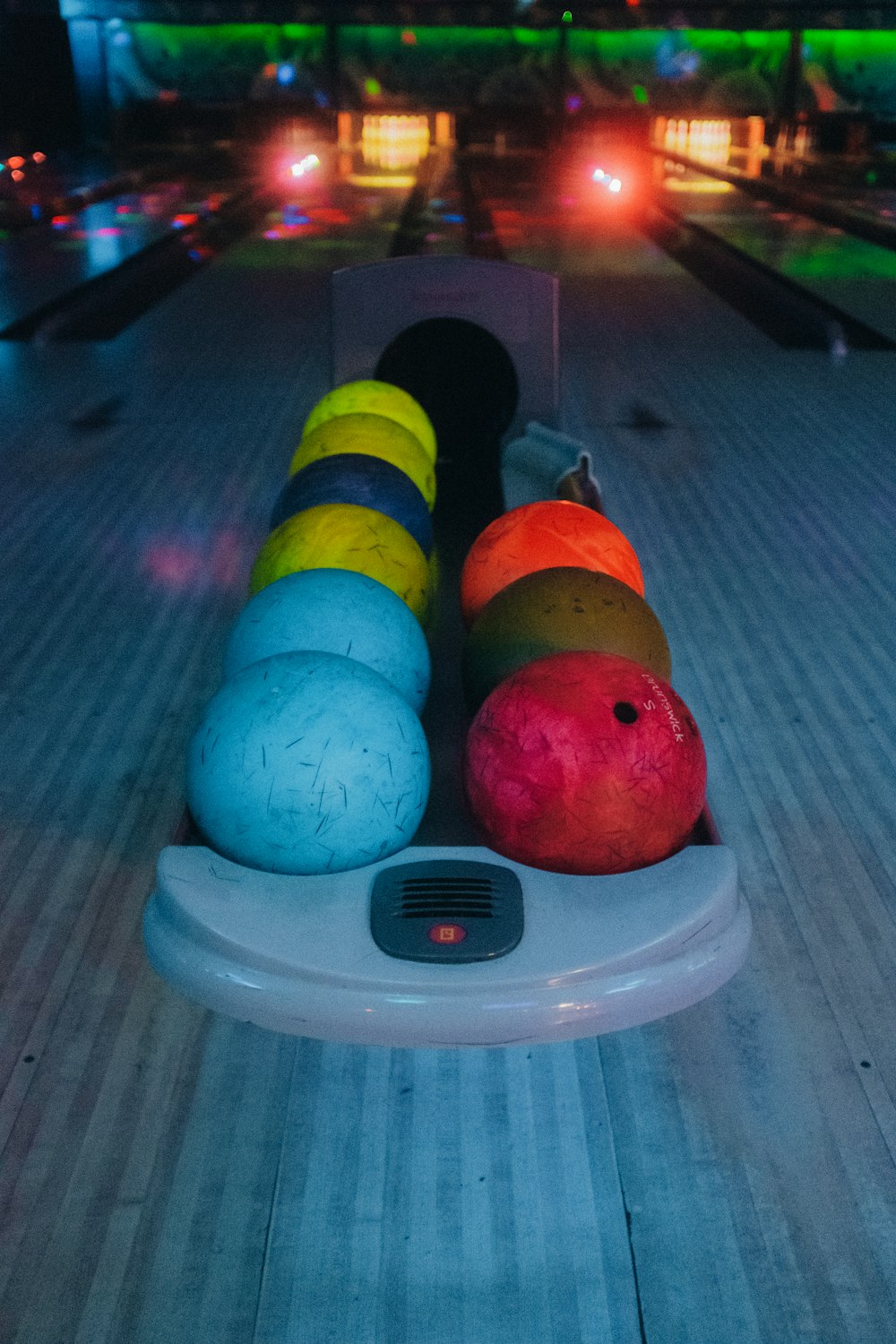 a row of bowling balls sitting on top of a bowling alley