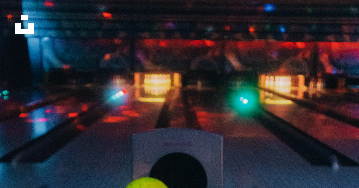 A row of bowling balls sitting on top of a bowling alley photo – Free ...