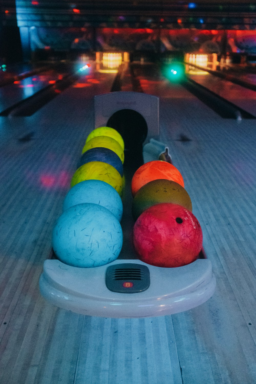 a row of bowling balls sitting on top of a bowling alley