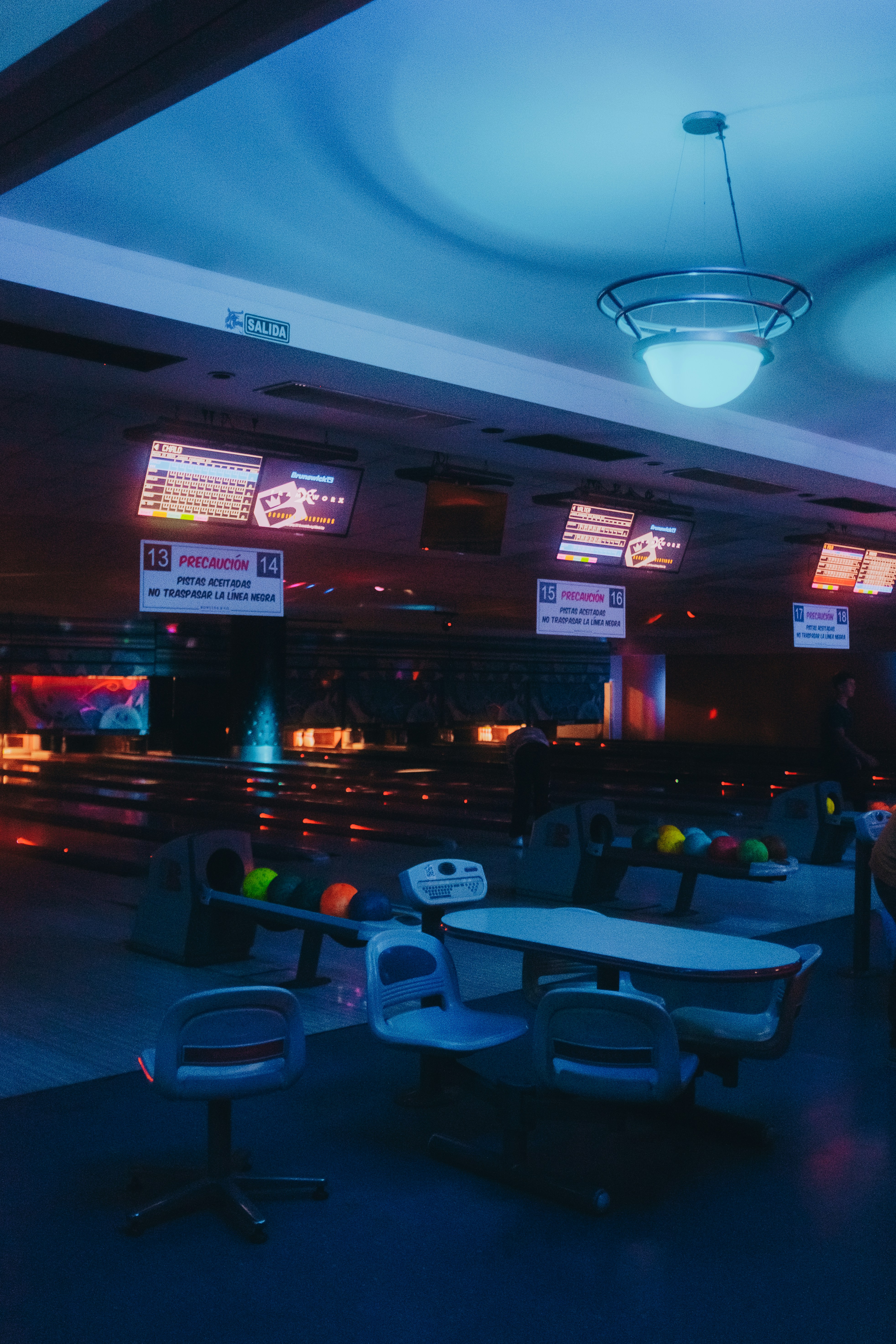a bowling alley filled with bowling balls and tables