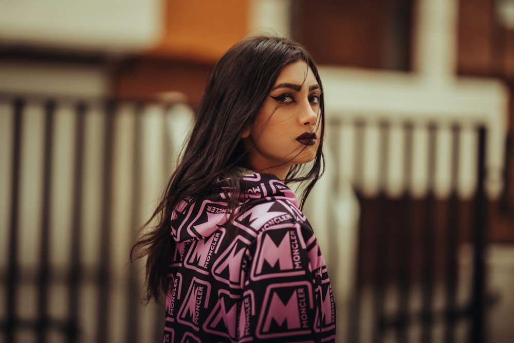 a woman with long hair wearing a pink jacket