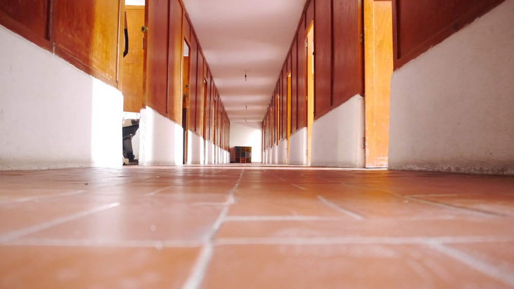 a long hallway with wooden doors leading to another room