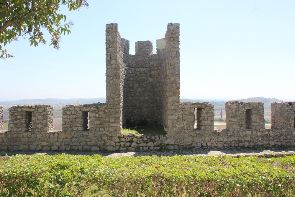 a stone castle sitting on top of a lush green field