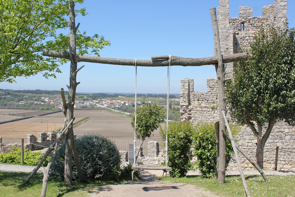 a wooden swing in the middle of a park