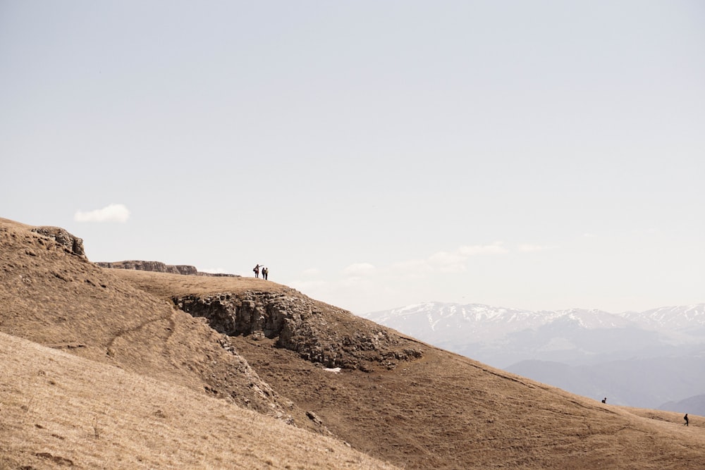 a couple of people standing on top of a hill