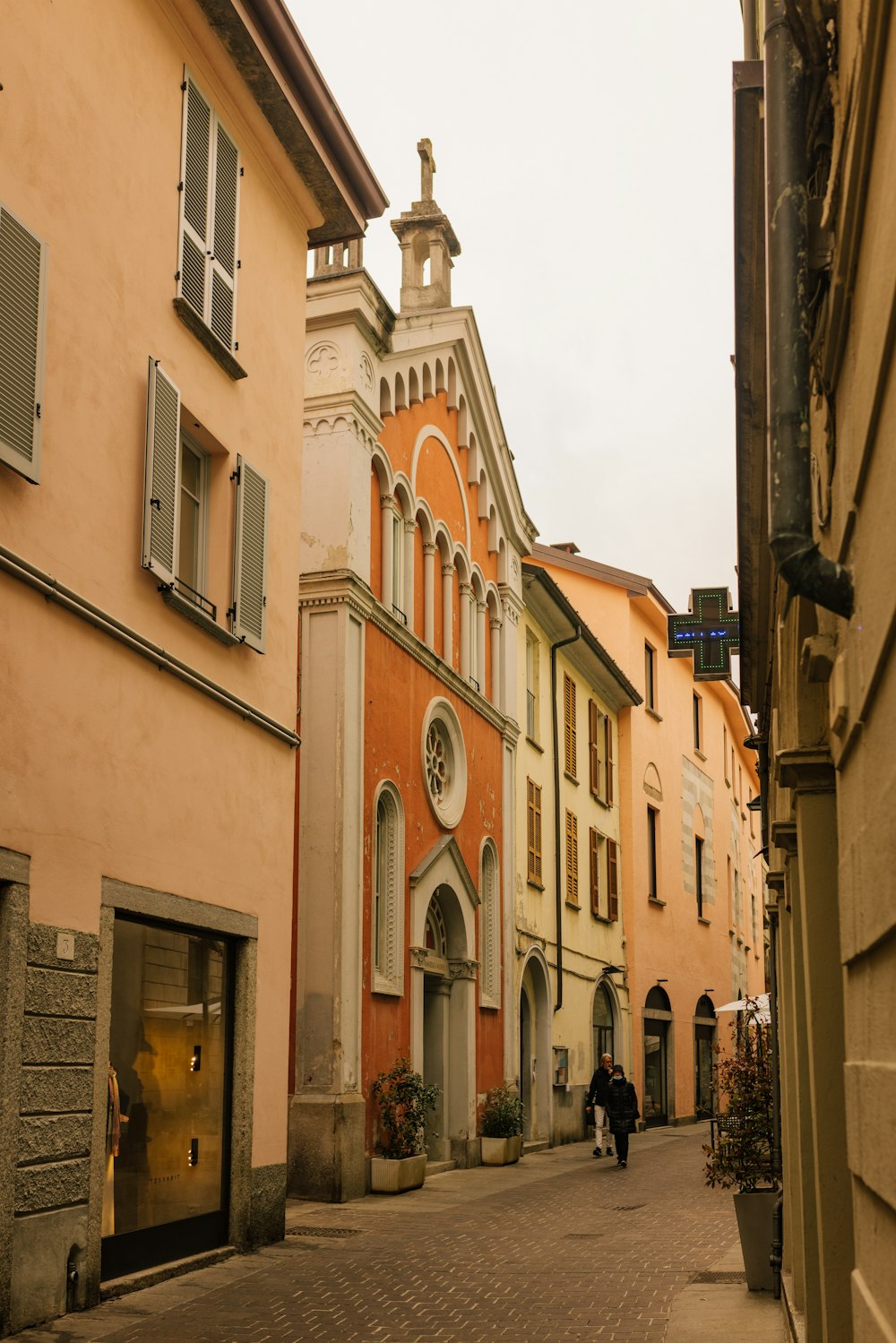 a cobblestone street lined with buildings and a clock tower