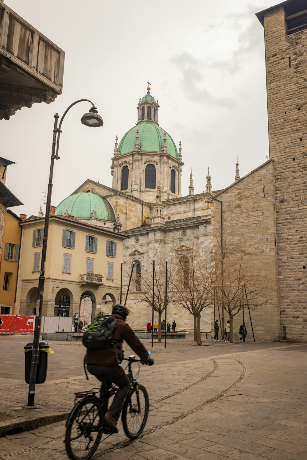 a man riding a bike down a street next to a tall building