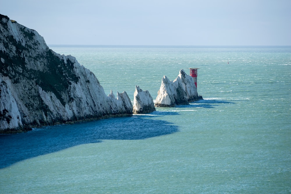 a group of white rocks sticking out of the ocean