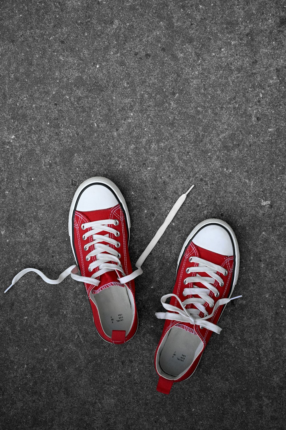 a pair of red sneakers with white laces