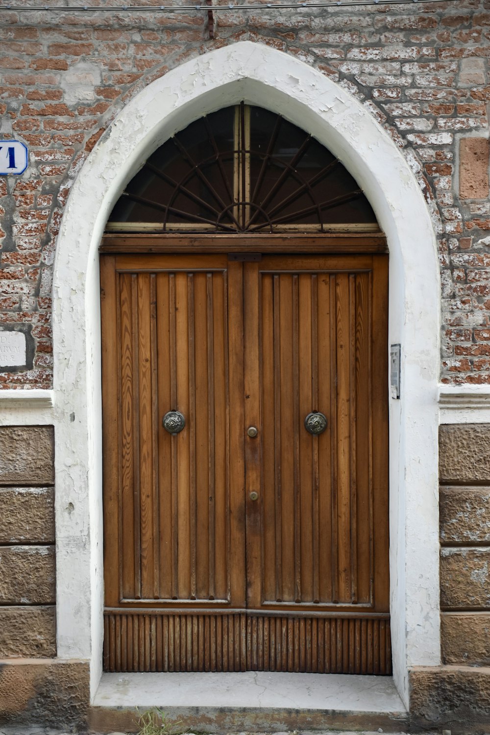 une grande porte en bois dans un bâtiment en briques