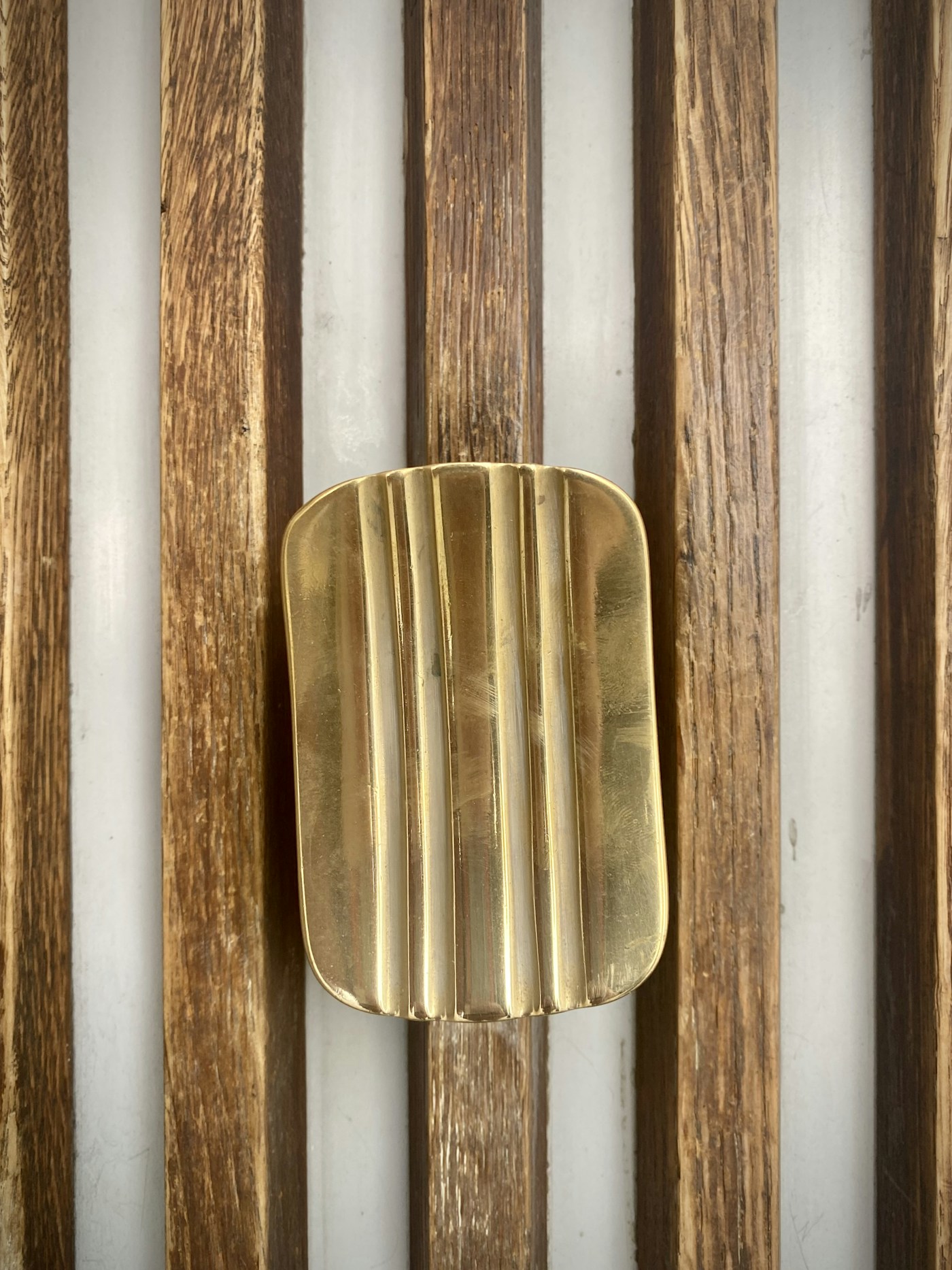 Brass rest detail against dark wood paneling