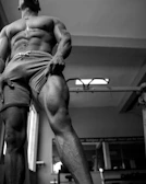 Close-up of a client’s toned glutes flexing after a tough set, sweat glistening under the gym lights.
