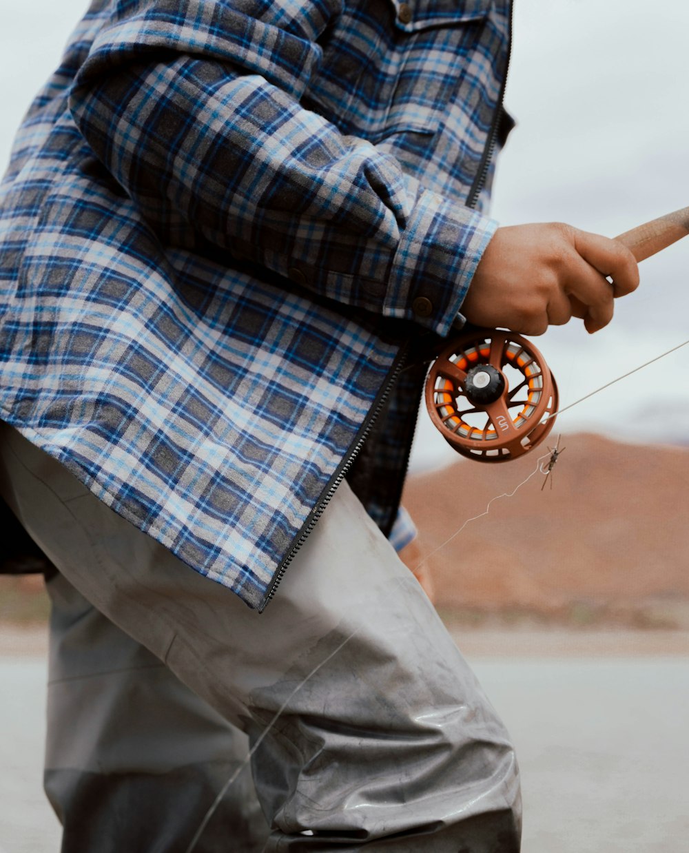 A man holding a fishing rod and a spinning wheel photo – Free Fish